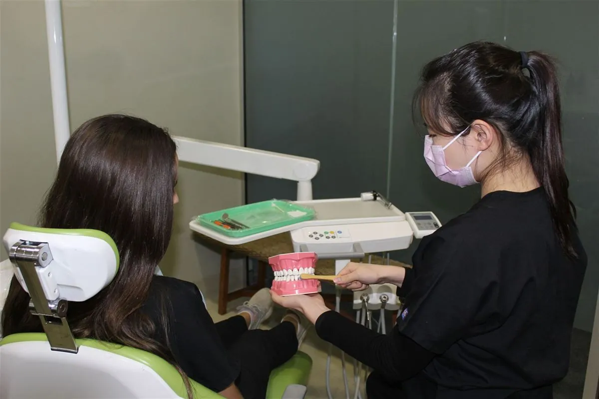 A Southside Dental team member showing a child how to brush using a tooth model