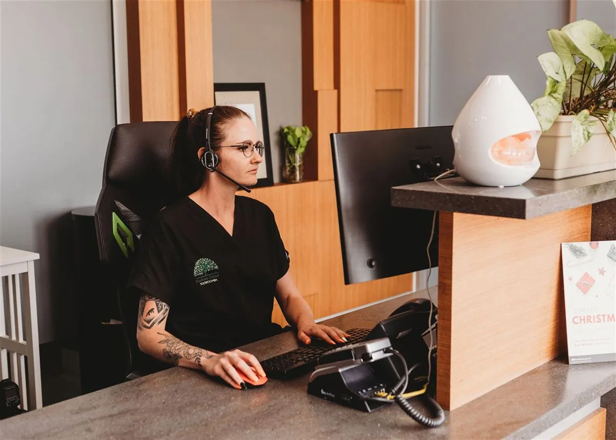 A friendly receptionist greeting a family at the Southside Dental Toowoomba front desk