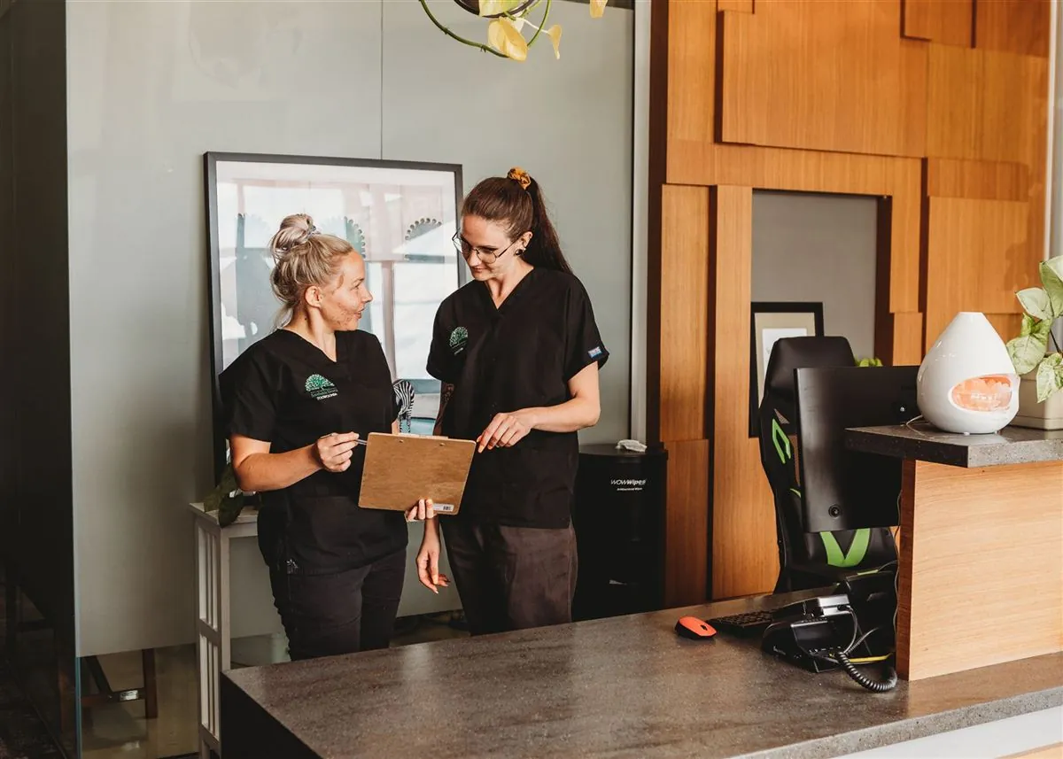 Two Southside Dental Toowoomba team members talking at the reception desk